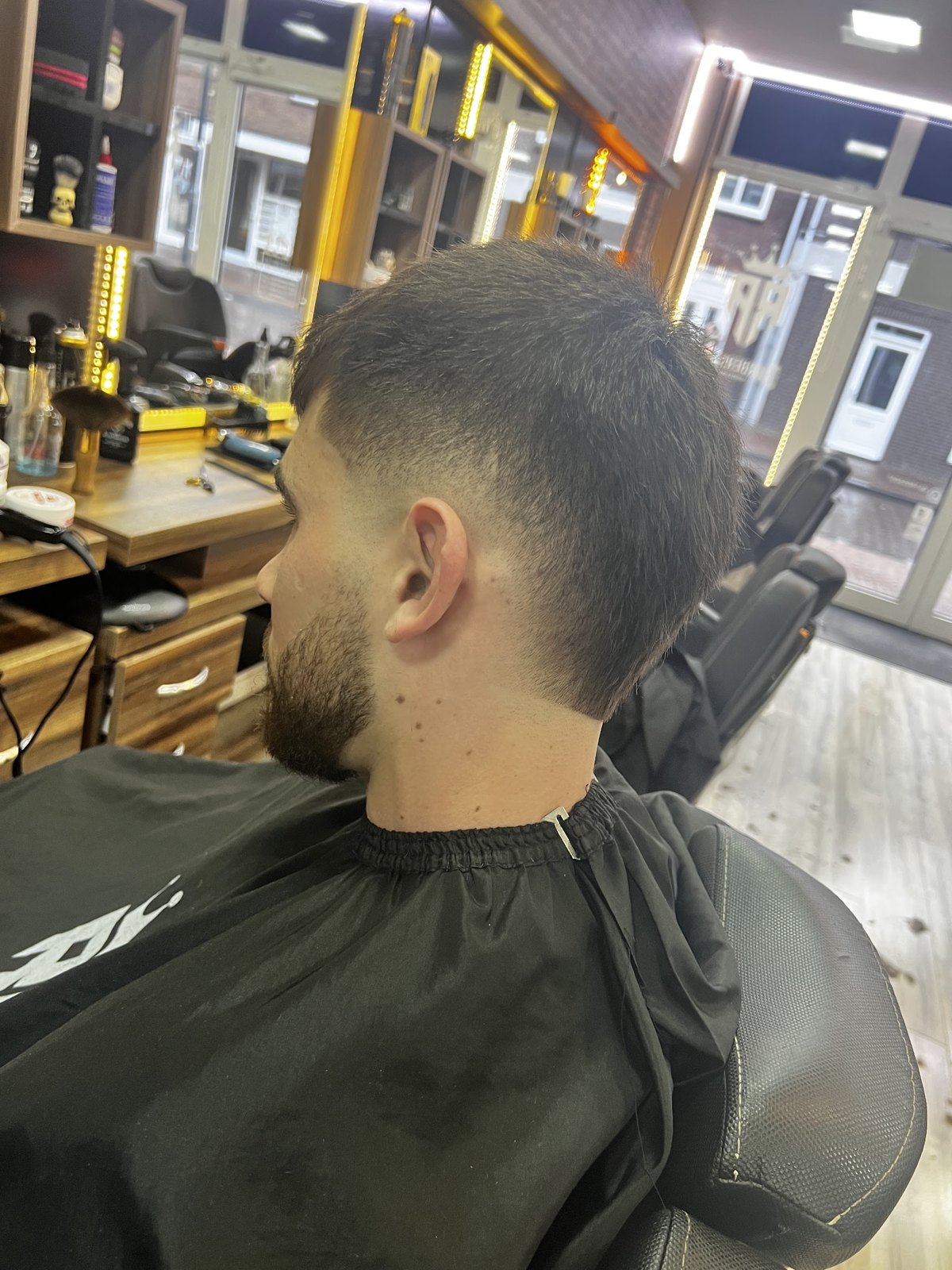 Fade met getrimde baard, voor de spiegelwand