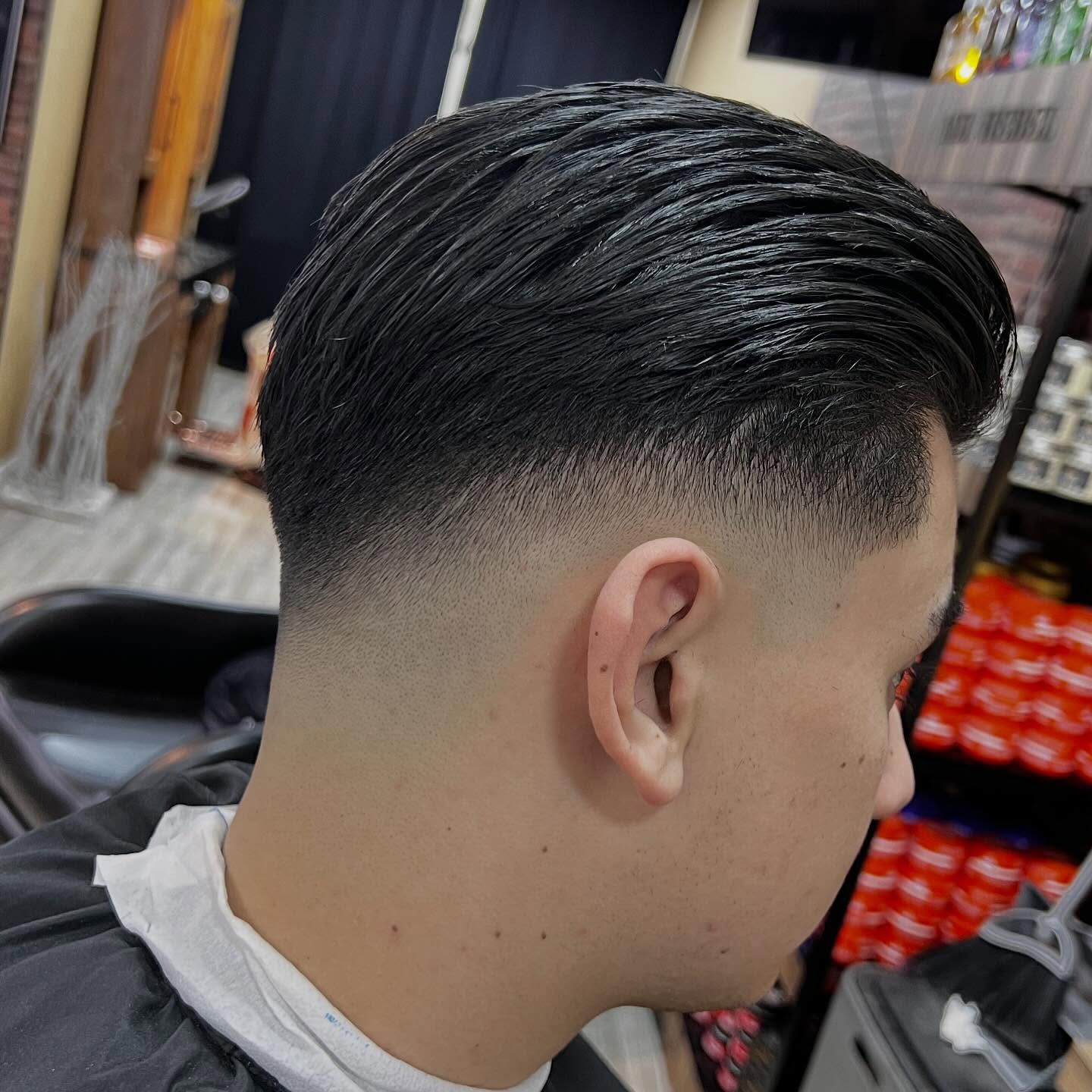 Low fade met het haar bovenop strak naar achteren gekamd
